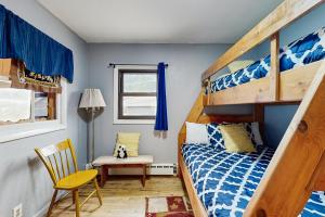 een slaapkamer met een stapelbed en een stoel bij Courtney Cottage - Permit #3479 in Estes Park