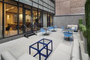 a patio with blue chairs and tables in a building at Best Western Premier Empire State Hotel in New York