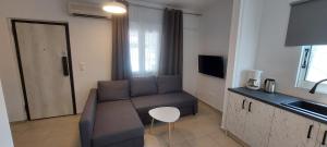 a living room with a couch and a kitchen at Dolce Far Niente Greece in Agioi Theodoroi
