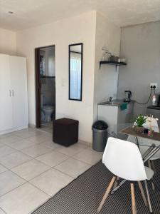 a room with a kitchen with a table and a chair at KwaSihle Guesthouse in Dobsonville