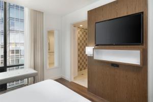 a bedroom with a flat screen tv on a wall at Best Western Premier Empire State Hotel in New York