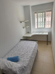a small bedroom with a bed and a window at Y&To in Grao de Castellón
