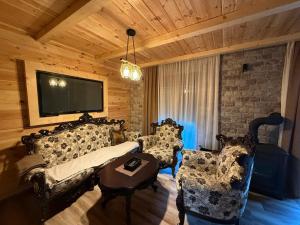 un soggiorno con divano, sedie e TV di Guest house Andrea a Žabljak
