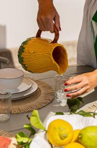 a person pouring liquid into a vase on a table at Just Like Home - Casa Cesário in Vila Praia de Âncora