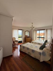 a bedroom with a large bed and a large window at OriXe e Kalma in Celanova