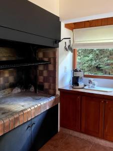a kitchen with a brick oven and a sink at Warm house in Bariloche - Breakfast - Barrio Belgrano in San Carlos de Bariloche +12 photos