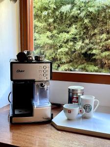 a coffee maker and two cups on a counter at Warm house in Bariloche - Breakfast - Barrio Belgrano in San Carlos de Bariloche