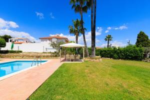 a swimming pool with a table and an umbrella at Villa Carmen - Peaceful Eco-Luxury with private pool in Cunit