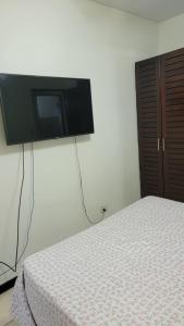 a bedroom with a bed and a flat screen tv on the wall at Playas del Coco Cocomarindo 23 in Coco