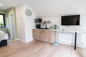 a kitchen with a desk with a tv on a wall at The Village at The Rocks - Luxury Glamping Resort in Newry