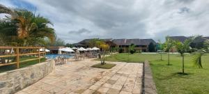 a resort with a patio and a swimming pool with umbrellas at Winterville Residence Gravatá por Yolo in Gravatá