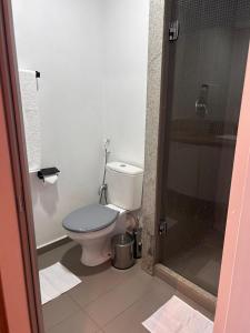 a bathroom with a toilet and a glass shower at Studio Neo Home São Caetano, aconchegante e compacto in São Caetano do Sul +5 photos