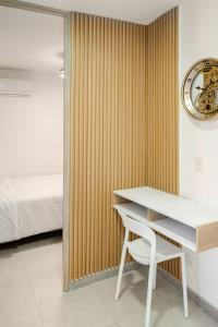 a bedroom with a desk and a bed and a clock at Apto refugio del mar in Cartagena de Indias +41 photos