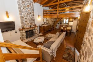 a living room with a couch and a fireplace at Cheerful 3 bedroom cottage with indoor fireplace in Avgón