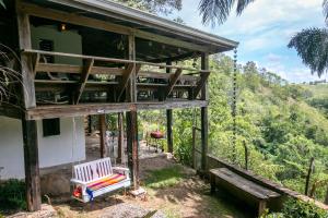 a tree house with a porch and a bench at 3BR Riverside Secret Retreat in Jarabacoa