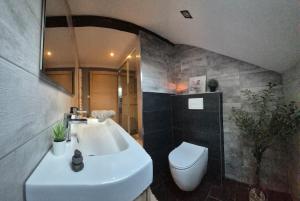 a bathroom with a white sink and a toilet at Escapade saint louis Basel in Saint-Louis +7 photos