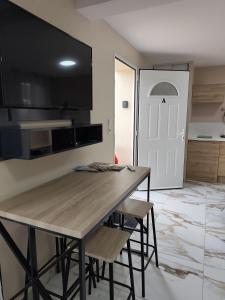 a kitchen with a wooden table and some chairs at Evasion Romantique&Jacuzzi! in Pruniers