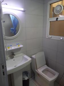 a bathroom with a sink and a toilet and a mirror at Middle East Hotel Dubai in Dubai