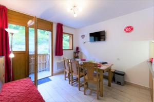 a dining room and living room with a table and chairs at Au bon endroit N1 - Appartement 2 pièces 5 à 7 personnes - proche pistes - coeur station - balcon in Orcières