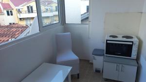 a room with a kitchen with a stove and a window at Mila apartman in Budva +1 photo