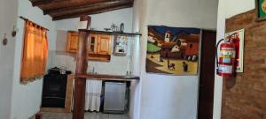 a kitchen with a stove and a refrigerator at Cabañas Juaniana in Villa Rumipal