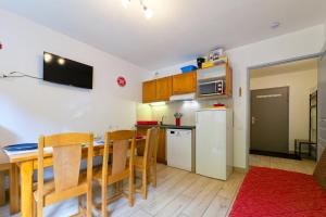 a kitchen and dining room with a table and a refrigerator at Au bon endroit N1 - Appartement 2 pièces 5 à 7 personnes - proche pistes - coeur station - balcon in Orcières +6 photos