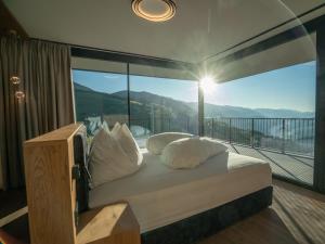 a bedroom with a bed and a balcony with a view at Hotel Purvita - Ski In Ski Out - Infinity Pool in Maranza +85 photos
