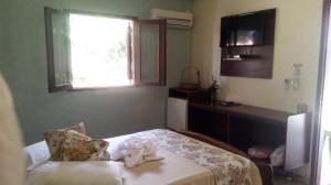 a small bedroom with a bed with a window at Recanto das Águas in Britânia