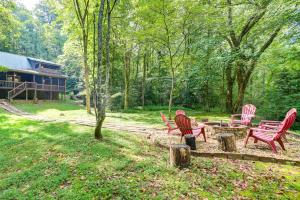 a group of red chairs and a picnic table in a yard at Picturesque Mountain Cabin with Hot Tub and Fire Pit! in Blue Ridge
