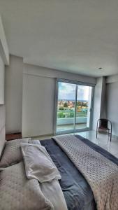 ein Schlafzimmer mit einem großen Bett mit einem großen Fenster in der Unterkunft Puebla Vista Malinche in Lomas de Angelopolis