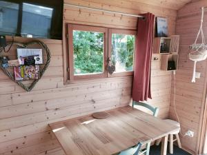 a wooden bench in a room with a window at La roulotte de Jane in Margon