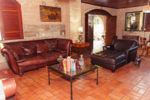 a living room with leather couches and a table at Pousada Aqualuna - São Miguel dos Milagres in São Miguel dos Milagres +80 photos