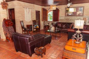 a living room with leather furniture and a couch at Pousada Aqualuna - São Miguel dos Milagres in São Miguel dos Milagres