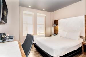 ein Hotelzimmer mit einem Bett und einem Schreibtisch in der Unterkunft The Gallivant Times Square in New York