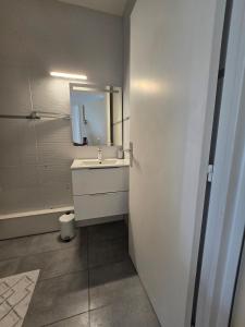 a bathroom with a white sink and a mirror at Quiet in Dijon