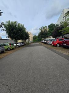 an empty street with cars parked in a parking lot at Quiet in Dijon