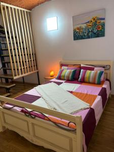 ブカレストにあるApartament Piața Victorieiのベッドルーム1室(カラフルな枕付きのベッド1台付)