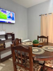 une table à manger avec des chaises et une télévision dans l'établissement La Parcela, à Recreo