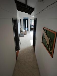 a hallway leading to a living room with a snake on the wall at Casa Descanso in Tunía