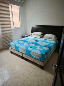 a bedroom with a bed with a blue comforter at Casa Descanso in Tunía