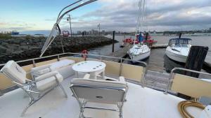 een boot met stoelen en een tafel en boten in het water bij HatTrick Sea View in Halifax