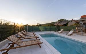 a swimming pool with lounge chairs next to at new renovation House Dinov San in Blato na Cetini