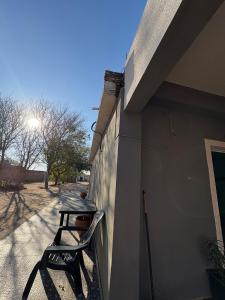 une chaise assise sur le côté d'un bâtiment dans l'établissement La Parcela, à Recreo