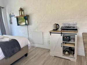 a bedroom with a bed and a table with a coffee maker at Joy-South Studio in Agulhas +32 photos