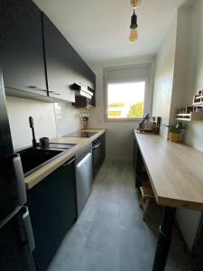 ブルージュにあるAppartement au bord du lacのキッチン(シンク、木製テーブル付)