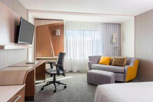 a hotel room with a bed and a desk and a chair at Courtyard by Marriott London in London