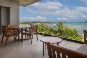 a dining room with a table and chairs and the ocean at 3BR Beachfront with Private Rooftop at Tankah Bay in Tulum