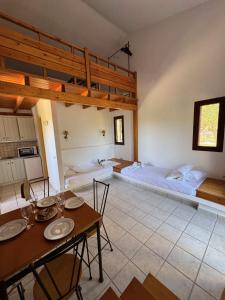 una habitación con una cama y una mesa con sillas en Olea bungalows, en Akrotiri
