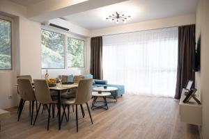 a dining room and living room with a table and chairs at Central Soul Suites in Ohrid