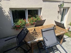 une table et des chaises en bois avec des fleurs dans une fenêtre dans l'établissement Nuit à la campagne, à Assenoncourt